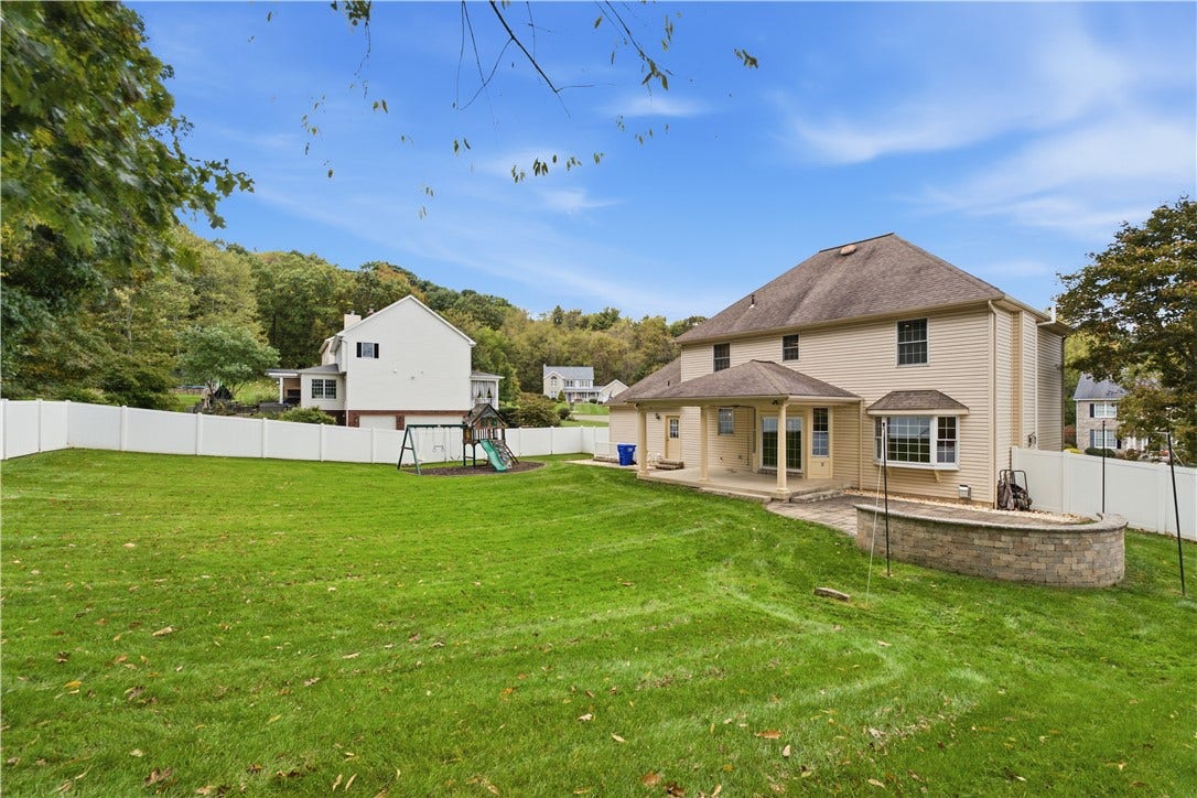 The beautiful, almost level, fenced-in back yard is a great size! It makes a great spot for enjoying the outdoors and entertaining with the covered back patio and fire pit