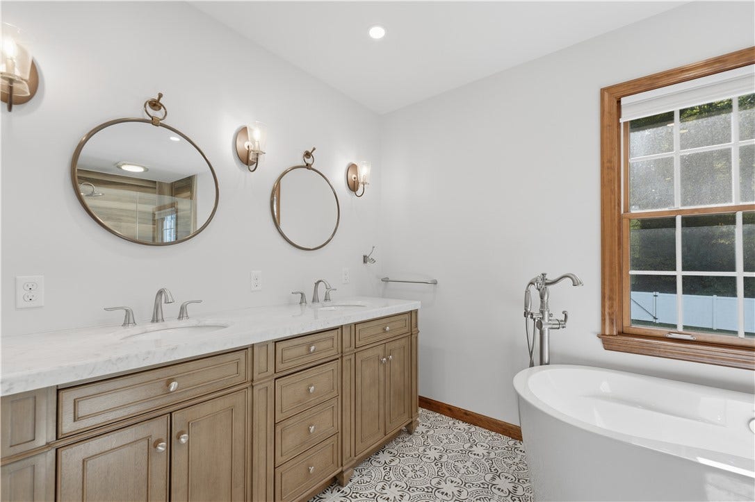 The Primary En-Suite Bathroom features double sinks, a relaxing soak tub, a separate shower with bench seating, and even heated floors!