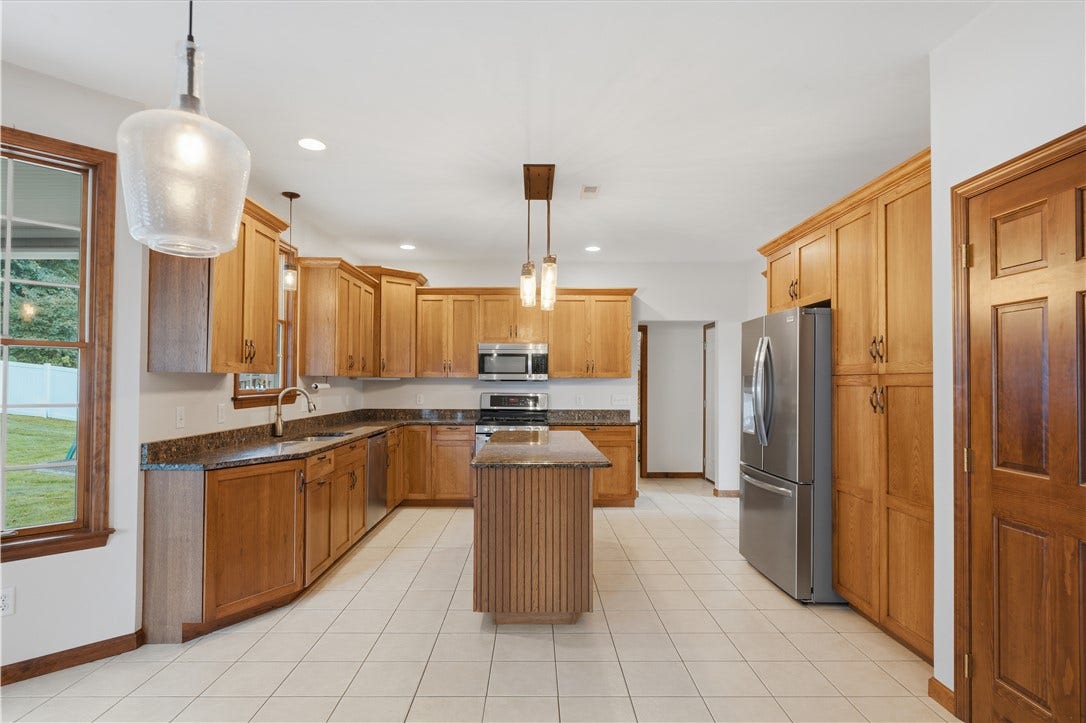 The Kitchen is approximately 22'x15' and flows right from the dining room. The huge kitchen area features granite countertops, custom cabinetry, stainless steel appliances, ample recessed lighting, a large kitchen island, and an open concept feel into the Living Room
