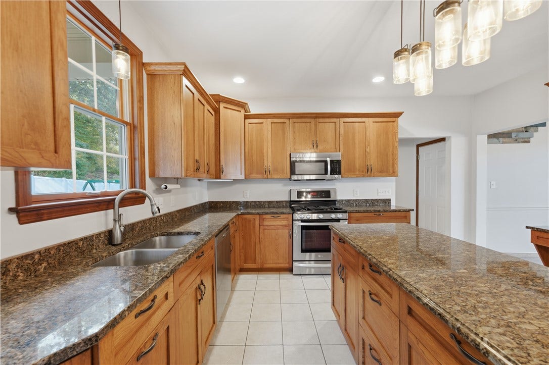 The Kitchen is approximately 22'x15' and flows right from the dining room. The huge kitchen area features granite countertops, custom cabinetry, stainless steel appliances, ample recessed lighting, a large kitchen island, and an open concept feel into the Living Room