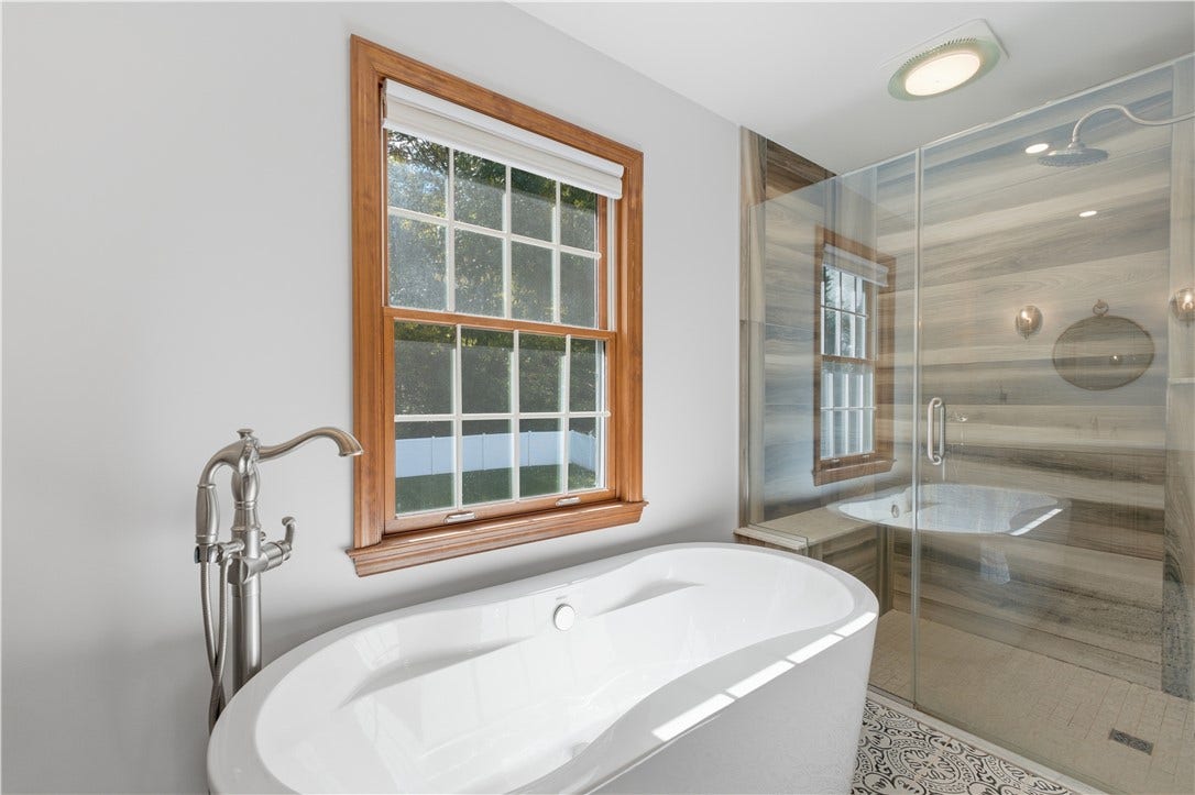 The Primary En-Suite Bathroom features double sinks, a relaxing soak tub, a separate shower with bench seating, and even heated floors!