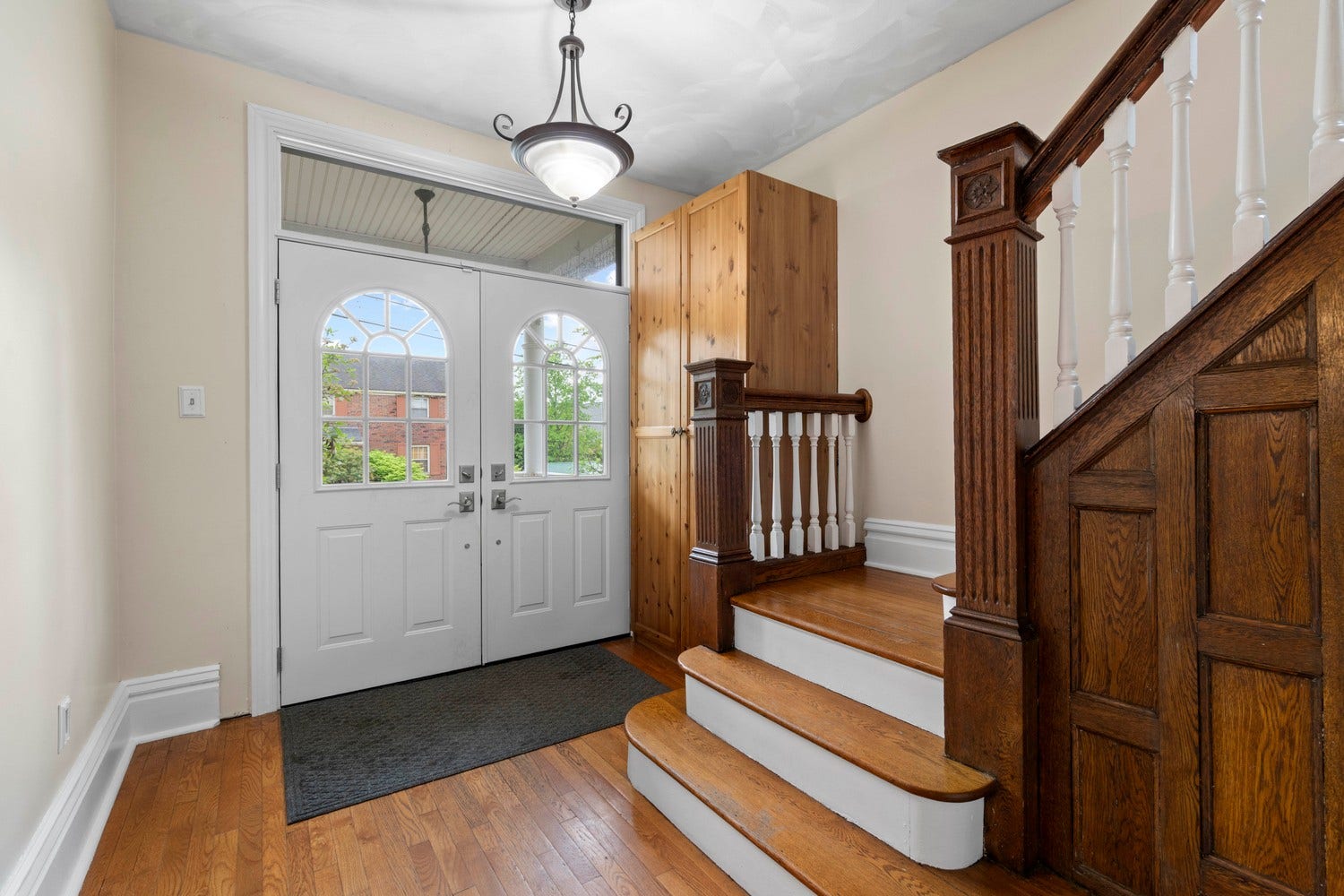 Step into the bright foyer and take in the charm of the architectural features...the newel posts, the transom window above the double doors, the original wood paneled staircase wall.  An updated built in closet added to accomodate coats and boots!