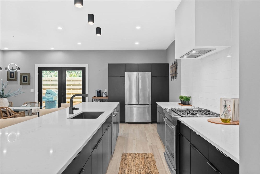 240 E Jefferson, Pittsburgh, PA 15212 Stunning contemporary kitchen featuring an oversized Carrara quartz waterfall island with generous seating, sleek custom Wolf cabinetry, premium JennAir stainless steel appliances, and a stylish tile backsplash. Modern lighting and clean architectural lines complete the space, which opens seamlessly to the living and dining areasperfect for everyday living and entertaining.