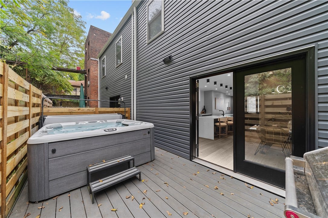 240 E Jefferson, Pittsburgh, PA 15212 Private deck located just off the dining area, featuring low-maintenance composite decking and wood privacy fencing. This outdoor space offers room for grilling, seating, and a hot tub, creating a versatile extension of the home's main living level.